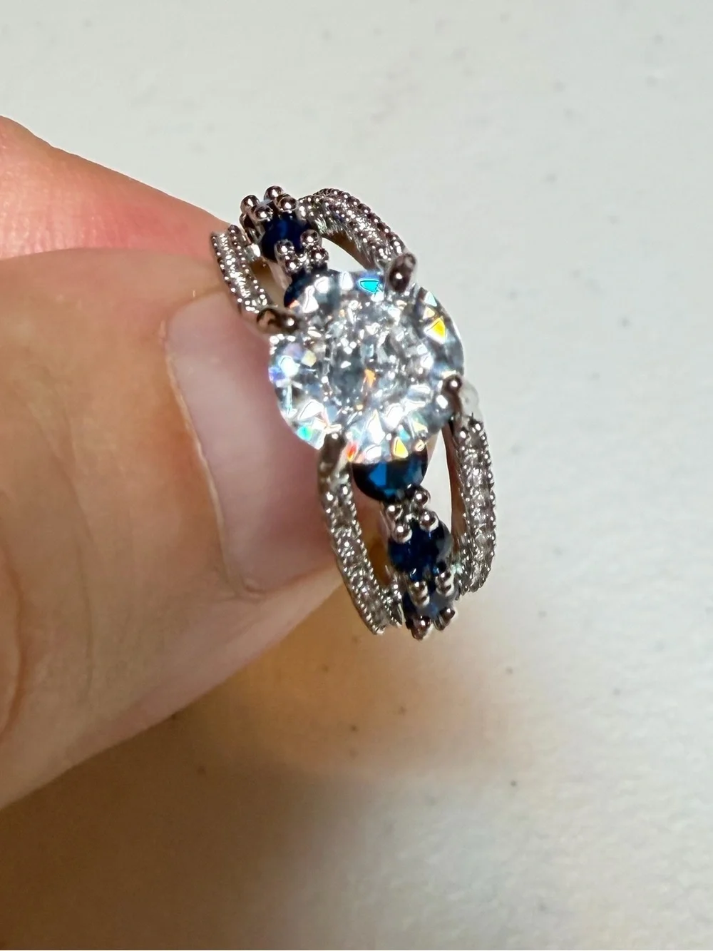 Silver Ring with Deep Blue Stones and Clear Center Gem.